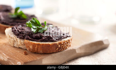 Tapenade di olive su una fetta di pane Foto Stock