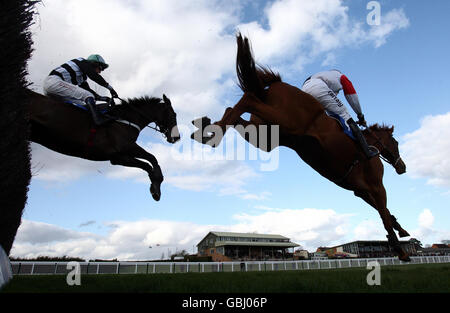 Mount Benger guidato da Christian Williams (a destra) batte Jimmy Bedney guidato da Lee Evans in secondo, sulla strada per la vittoria nella Lindley approvvigiona Beginners' Chase durante il meeting di primavera pomeriggio all'ippodromo di Hereford. Foto Stock