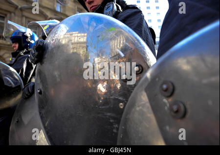 Un riflesso dei manifestanti pacificamente seduti si riflette in uno scudo di polizia nei pressi di Queen Victoria Street, nel centro di Londra, durante le proteste del G20. Foto Stock