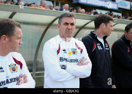 Owen Coyle (centro), direttore di Burnley, con l'assistente Sandy Stewart (a sinistra) e il primo allenatore di squadra Steve Davis, sulla linea di contatto prima del calcio d'inizio. Foto Stock