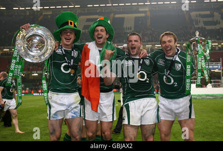 Tommy Bowe (a sinistra), Rob Kearney (2° a sinistra), Jamie Heaslip (2° a destra) e Stephen Ferris (a destra) celebrano con la tripla corona e il 6 Nations Trophy di fronte ai fotografi Foto Stock