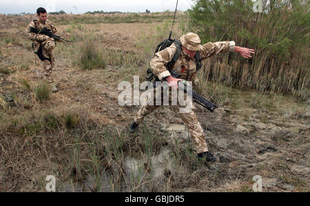 RFL Matt Leonard salta su un fossato d'acqua cinque a Leaf Island, provincia di Basra, durante un'operazione di caccia ai ribelli che sparano razzi nel campo alla base aerea di Basra. Foto Stock