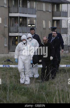 Gli investigatori della scena del crimine rimuovono il corpo di un uomo che si credeva fosse alla fine degli anni '20, che è stato scoperto sdraiato al largo di Belcamp Lane, Coolock, a nord di Dublino intorno alle 16:00 da un passer-by. Foto Stock