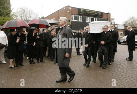 Il direttore funebre Barry Albin-Dyer cammina davanti alla bara di Jade Goody, che viene portata dai direttori funerali di fa Albin & Sons a Bermondsey, prima della processione funeraria attraverso Bermondsey, nel sud-est di Londra, fino alla chiesa di San Giovanni Battista in Essex, dove si svolgeranno i funerali. Foto Stock