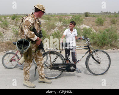 Il maggiore Jim Faux, di A-Company, 5 Fucili, saluta un ragazzo fuori al-Hartha, a nord di Basra, Iraq. Foto Stock