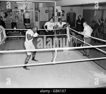 Rubin carter si allenò in palestra di Joe Bloom in preparazione alla sua lotta contro Harry Scott alla Royal Albert Hall, guardata dal suo manager Pat Amato (r) Foto Stock