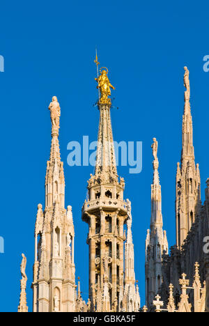 Statua della Madonnina sulla guglia della cattedrale contro il cielo blu, Milano, Italia, Europa Foto Stock