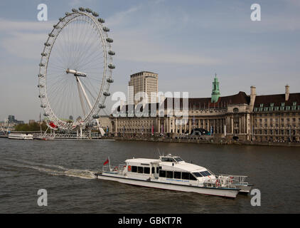 Una barca turistica, gestita dai Thames Clippers, naviga oltre il London Eye sul Tamigi Foto Stock
