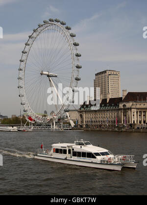 Una barca turistica, gestita dai Thames Clippers, naviga oltre il London Eye sul Tamigi Foto Stock