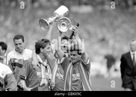 (L-R) Nottingham Forest's Garry Parker, Brian Laws e Steve Hodge celebrano la vittoria mentre loro e i loro compagni di squadra sfilano la Littlewoods Cup, tenuta da Tommy Gaynor (c, nascosto), intorno a Wembley dopo la loro vittoria del 3-1 Foto Stock