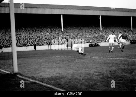 Il portiere di Leeds United Gary Sprake (l) si tuffa per salvare, guardato dal compagno di squadra Willie Bell (seconda r) e dal Manchester United John Connelly (r) Foto Stock