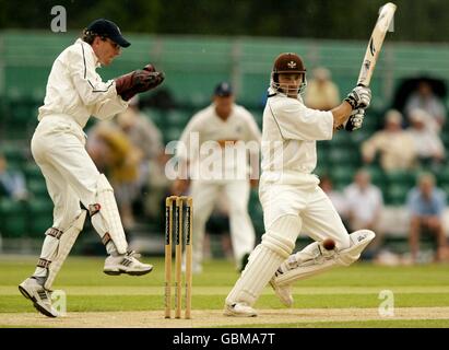 Mark Ramprakash di Surrey taglia la palla per quattro corse sulla sua strada per un secolo. Tony Frost del Warwickshire è impotente Foto Stock