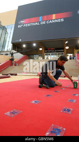 I lavoratori piazzano numeri per segnare le posizioni dei fotografi mentre preparano il tappeto rosso fuori dal Palais des Festivals, a Cannes, in Francia, prima dell'inizio del 62° Festival de Cannes, che inizia domani. Foto Stock