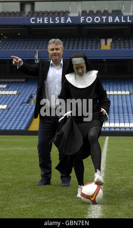 I membri del cast di Sister Act: The Musical, vestiti da monache, hanno una sessione di allenamento del manager del Chelsea Guus Hiddink allo Stamford Bridge Stadium di Londra. Foto Stock