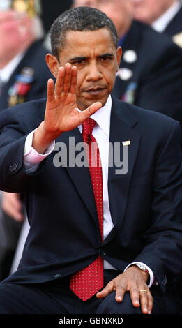 Il presidente DEGLI STATI UNITI Barack Obama ondeggia ai veterani durante un servizio commemorativo al cimitero americano di Colleville-sur-Mer, in Normandia, in Francia, nel 65° anniversario degli sbarchi del D-Day. Foto Stock