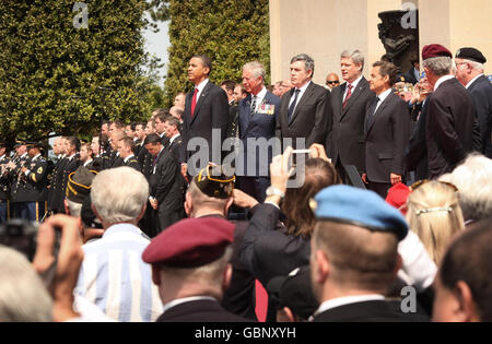 Il presidente DEGLI STATI UNITI Barack Obama (a sinistra) si trova con (da sinistra a destra) il principe del Galles, il primo ministro britannico Gordon Brown, il primo ministro canadese Stephen Harper e il presidente francese Nicolas Sarkozy durante un servizio commemorativo presso il cimitero americano in Normandia a Colleville-sur-Mer, in Francia, nel sessantacinquesimo anniversario degli sbarchi del D-Day. Foto Stock