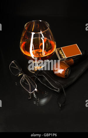 Bicchiere di whiskey e tubo di fumo. Il cognac in vetro. Bicchiere di brandy. Cognac Francia. Tubo di fumare e bere scotch. Foto Stock