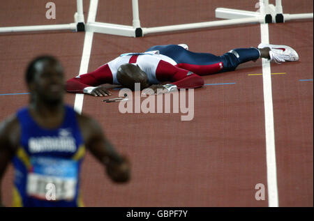 Atletica - Giochi Olimpici di Atene 2004 - Hurdles da 110 m - Round 2 - Heat 2. Il Johnson di Allan degli Stati Uniti è lasciato messo a terra dopo essere caduti al secondo da ultimo ostacolo nel calore semifinale degli Hurdles degli uomini 110m Foto Stock