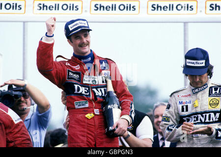 Nigel Mansell cita l'aria in festa dopo aver vinto il Gran Premio di Gran Bretagna a Brands Hatch. Il suo compagno di squadra Williams-Honda Nelson Piquet (r) sembra deluso dal suo secondo posto finale Foto Stock