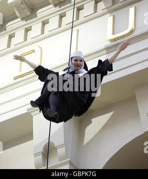 Le monache abseil fuori del teatro, durante la notte stampa di Sister Act: Il Musical al London Palladium nel centro di Londra. Foto Stock