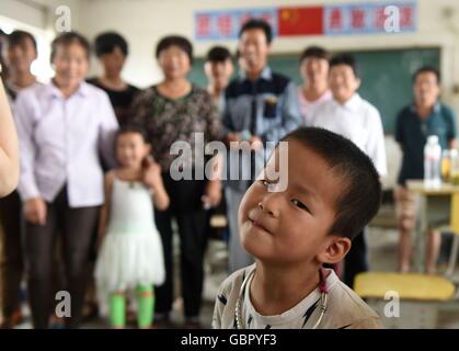 Tongcheng, cinese della provincia di Anhui. 7 Luglio, 2016. La cinque-anno-vecchio ragazzo Zhao Jinxing in posa per una foto con altre persone colpite dall alluvione in un aula in Kongcheng middle school di Kongcheng township di Tongcheng City, est cinese della provincia di Anhui, Luglio 7, 2016. La scuola media è diventata un temporaneo rifugio per la popolazione locale colpita dall alluvione che ha colpito la cittadina di recente. Credito: Wu Xiaoling/Xinhua/Alamy Live News Foto Stock