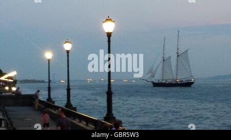 New York, Stati Uniti d'America. 7 Luglio, 2016. Un tradizionale stile clipper ship consente di spostarsi tra la parte inferiore del fiume Hudson nei pressi di New York Battery Park City in Lower Manhattan il giovedì sera. New York City sperimentato eccezionalmente caldo e umido clima estivo di oggi. (Telefono cellulare immagine) Credito: Adam Stoltman/Alamy Live News Foto Stock