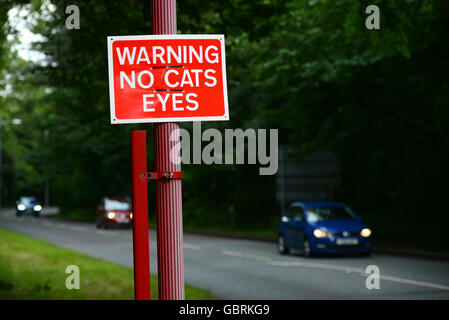 Il traffico che passa senza gatti occhi segno di avvertimento sulla strada al tramonto, Leeds Yorkshire Regno Unito Foto Stock