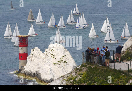 Gli spettatori hanno una buona visione degli yacht che competono nella JP Morgan Asset Management Round the Island Race mentre passano il faro di Needles durante una gara Round the Island, Isola di Wight. Foto Stock
