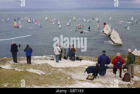 Gli spettatori hanno una buona visione degli yacht che competono nella JP Morgan Asset Management Round the Island Race mentre passano il faro di Needles durante una gara Round the Island, Isola di Wight. Foto Stock