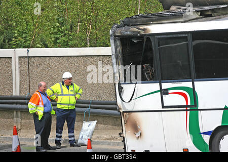 La scena in cui un autobus che trasporta i bambini della scuola ha preso il fuoco oggi sull'autostrada M50 occupata a Dublino. Foto Stock