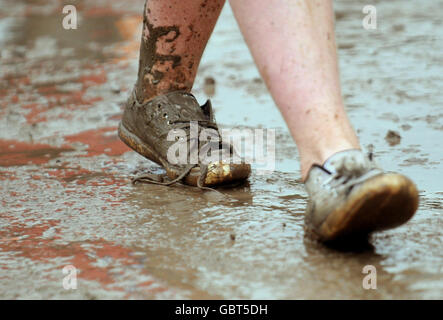 Glastonbury Festival 2009 - giorno uno. Un uomo cammina attraverso il fango durante il Glastonbury Festival 2009 a Pilton, Somerset. Foto Stock