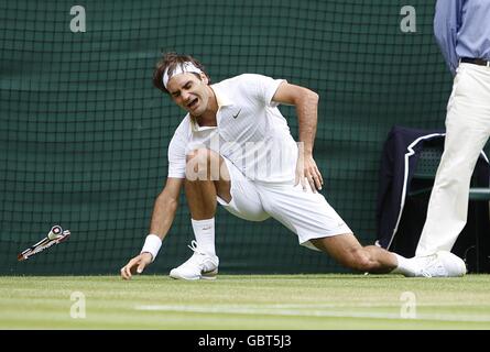 Roger Federer in Svizzera inciampa e cade durante la sua partita con Philipp Kohlschreiber in Germania durante i Wimbledon Championships 2009 presso l'All England Tennis Club Foto Stock