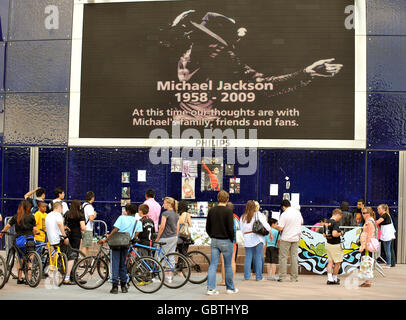 Un gruppo di fan di Michael Jackson si esibisce in un santuario del cantante americano, morto a Los Angeles giovedì, fuori dalla O2 Arena, Londra. Foto Stock