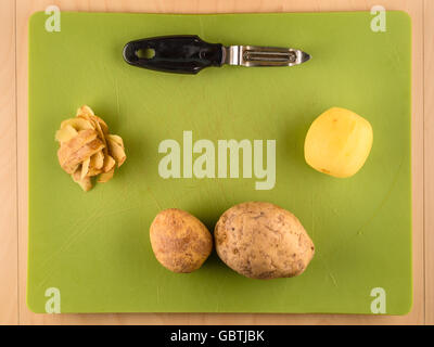 Patate e bucce sul verde della scheda in plastica Foto Stock