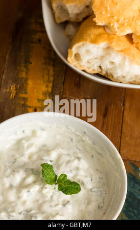 Yogurt, menta e salsa di limone con pane bianco su un tavolo di legno Foto Stock