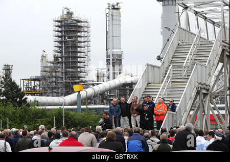 I lavoratori edili ascoltano i loro funzionari e portavoce, poiché alcuni hanno bruciato i loro avvisi di licenziamento al di fuori della raffineria di Lindsey in un atto di sfida contro il gigante petrolifero francese Total. Foto Stock