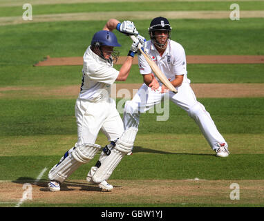 Il battsman di Warwickshire Tim Ambrose difende la palla, guardato dal fielder inglese Alastair Cook durante un amichevole incontro a Edgbaston, Birmingham. Foto Stock