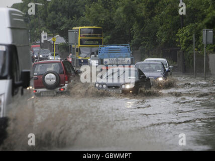 Le automobili si fanno strada attraverso una sezione allagata di Santry Avenue a Dublino. L'aeroporto di Dublino ha registrato due settimane di precipitazioni medie in un'ora durante le forti docce della scorsa notte. Foto Stock