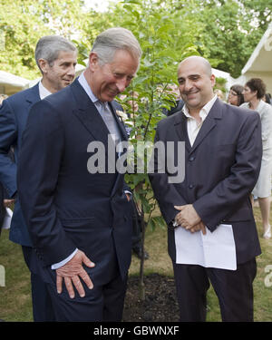 Il Principe del Galles, nel suo ruolo di presidente del Business in the Community (BITC) con il comico Omid Djalili, a destra, durante un ricevimento per celebrare il 12 ° Business in the Community (BITC) National Awards for Excellence, nei giardini di Clarence House, Londra. Foto Stock