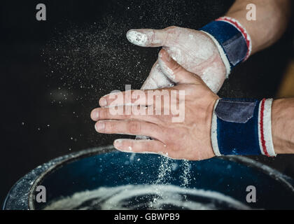 Preparazione delle mani con il gesso prima di iniziare la calistenica, ginnastica fitness training. Foto Stock