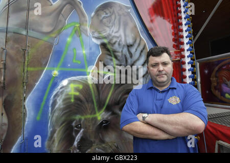 David Duffy, proprietario del circo di Duffys, si erge di fronte ai graffiti dal fronte di Liberazione animale, dopo che il gruppo ha cercato di accendere alcuni veicoli e ha usato acido e colla super per danneggiare altri a Goatstown, Dublino. Foto Stock