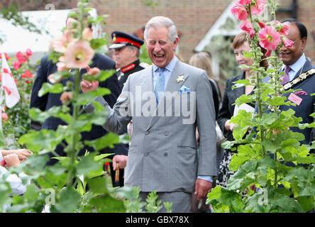 Il Principe del Galles, centro, patrono dell'Associazione Almshouse, cammina attraverso un'assegnazione durante una visita alle case di St Pancras nel nord di Londra per celebrare il 150° anniversario delle Almshouses. Foto Stock