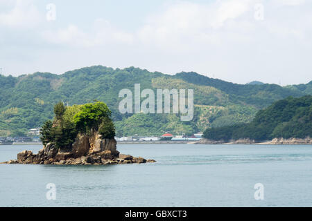 Un piccolo isolotto roccioso lungo la superstrada Nishiseto in Seto Inland Sea Foto Stock