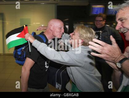 L'ex soldato Derek Graham viene accolto dalla suocera Eva Fitzgerald dopo essere arrivato all'aeroporto di Dublino con il premio Nobel Mairead Maguire, dopo che sono stati deportati da Israele per aver tentato di portare aiuto a Gaza. Foto Stock