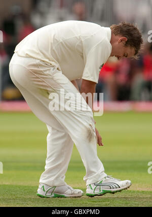 Nathan Hauritz dell'Australia tiene la mano dopo averla ferita durante il primo giorno della seconda partita di test npower a Lord's, Londra, durante un colpo di Andrew Strauss dell'Inghilterra. Foto Stock