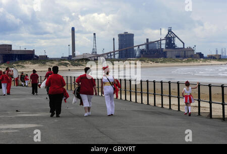 I membri di una band di Cleveland Marching partiscono dopo una marcia in cui i Teeside Steelworkers con i loro sostenitori e le loro famiglie marciano attraverso Redcar per evidenziare la minaccia per la locale pianta di Corus (nella foto in background), quando un consorzio di società ha concluso un contratto di 10 anni per l'acquisto dell'acciaio di 150 anni, mettendo a rischio 2,000 posti di lavoro. Foto Stock