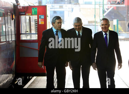 Il primo ministro Gordon Brown e il primo ministro Rhodri Morgan sono accolti dal segretario gallese Peter Hain (a destra) all'arrivo alla stazione centrale di Cardiff. Foto Stock