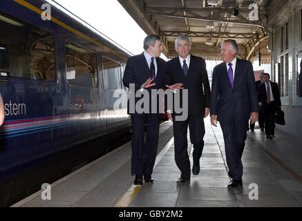 Il primo ministro Gordon Brown e il primo ministro Rhodri Morgan sono accolti dal segretario gallese Peter Hain (a destra) all'arrivo alla stazione centrale di Cardiff. Foto Stock