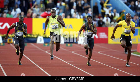 Usain Bolt (seconda a sinistra) della Giamaica si allontana dal campo sulla strada per vincere la finale di 100m come il connazionale Asafa Powell (estrema destra) poteva gestire solo il sesto posto durante il Gran Premio di Londra Aviva al Crystal Palace National Sports Center di Londra. Foto Stock