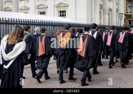 Laureati dell'Università di Cambridge per raggiungere a piedi la loro cerimonia di laurea presso la Casa del Senato, Cambridge, Inghilterra, Regno Unito Foto Stock